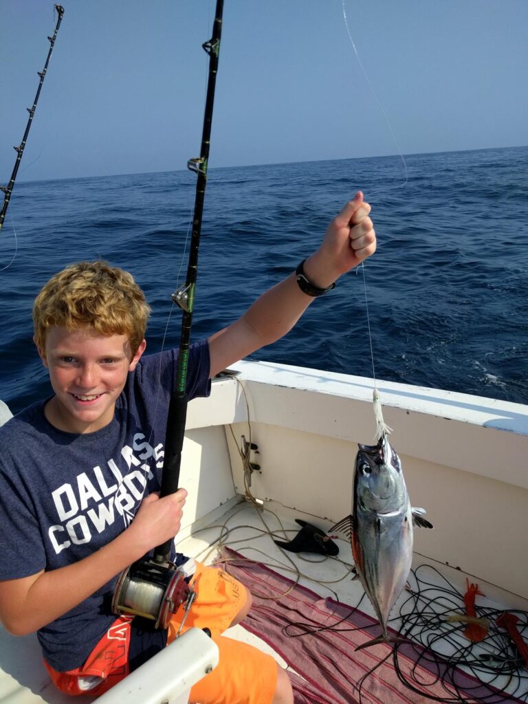 This image is the cover photo for Cow and Girl's tuna noodle recipe. The image features Josiah, who is one of Cow and Girl's taste testers, catching a tuna fish.