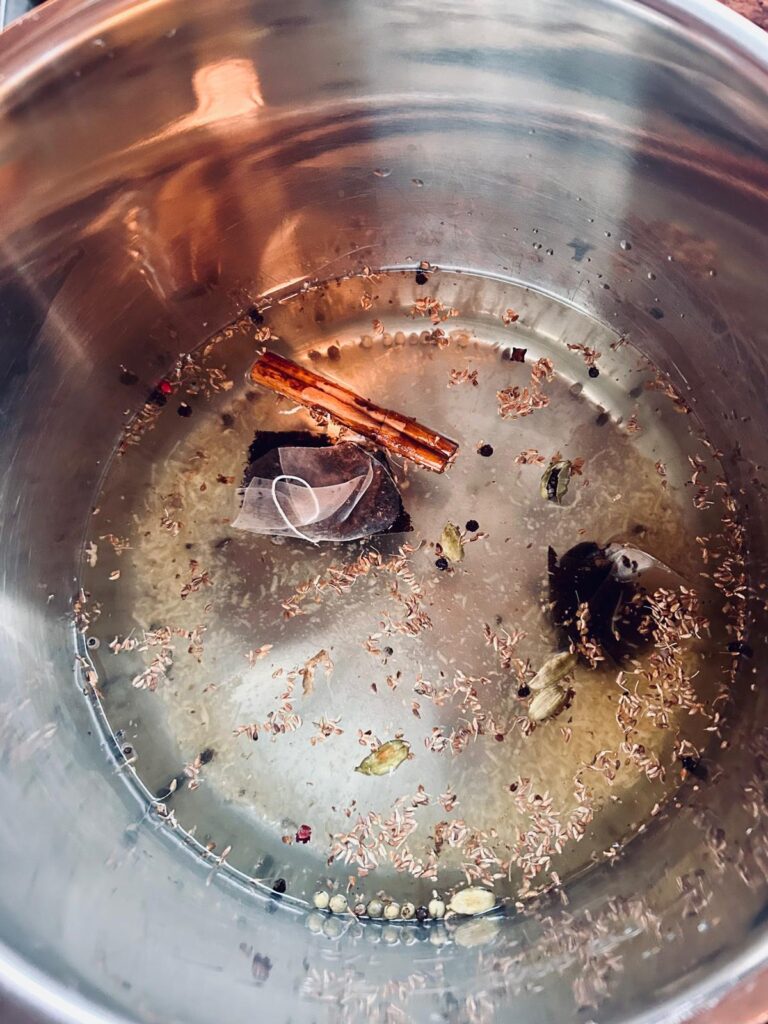 This is an image of an insta pot full of the ingredients for homemade chai tea ready to be brewed.