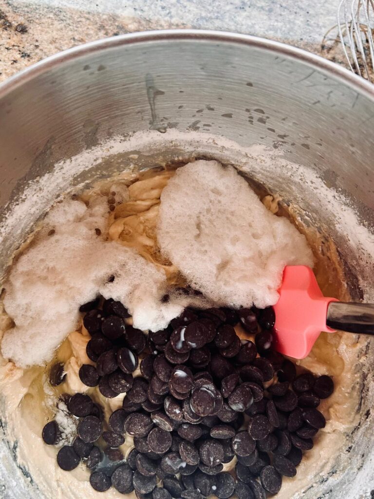 This is an image of chocolate chips and egg whites being folded into protein banana bread batter.