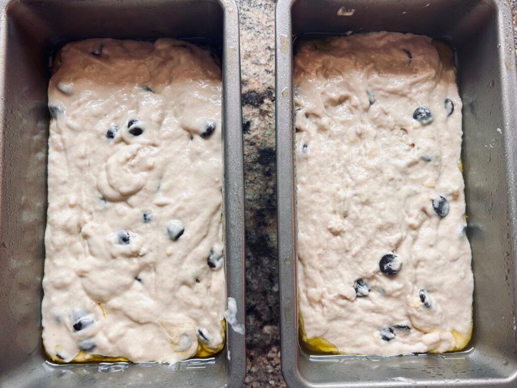 Two loafs of banana bread batter in bread pans ready to be put in the oven.