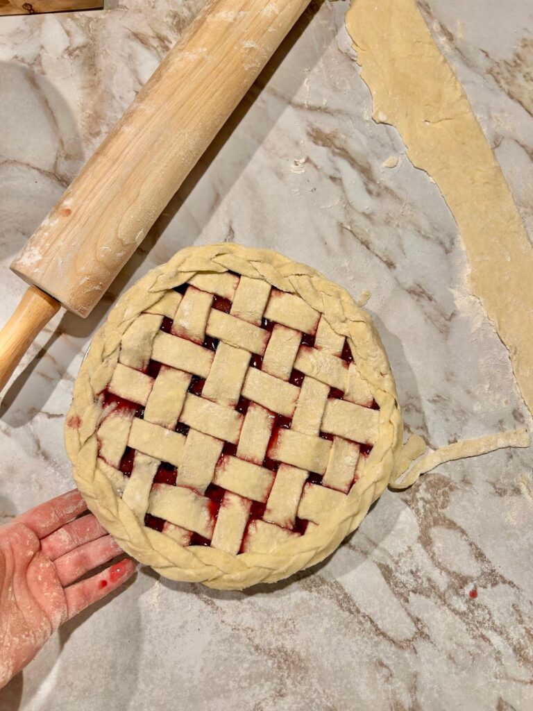 Pie compleated and ready to bake. The pie has peach and blackberry filling. The top crust is laced together with a pasry braid around the edge of the pie.